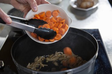 Gemüse und Kräuter in die Pfanne geben.