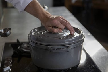 Den Herd auf schwache Hitze zurückdrehen und den Deckel auf die Pfanne legen.