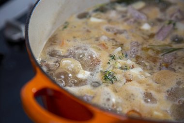 Das Kalbfleisch und das Gemüse während des Dünstens durchrühren
