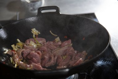 Wenn das Öl heiß ist, das Kalbfleisch hinzufügen.