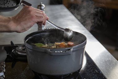 Das Gemüse und die Flüssigkeit über das Fleisch löffeln.