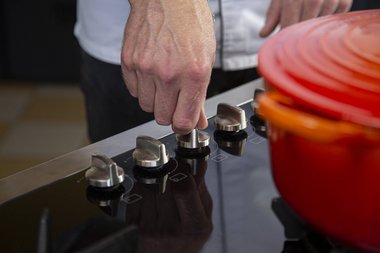 Den Herd auf schwache Hitze zurückdrehen und den Deckel auf die Pfanne legen.