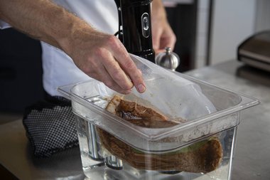 Das vakuumierte Kalbfleisch in das Sous Vide-Bad legen.