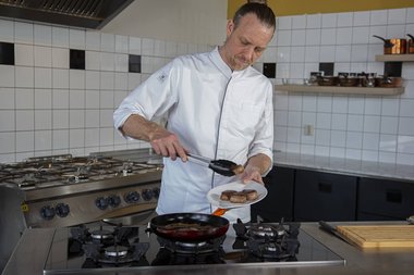 Das Kalbfleisch aus der Pfanne nehmen