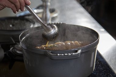 Die Schmorflüssigkeit als Basis für die Sauce durchseihen.