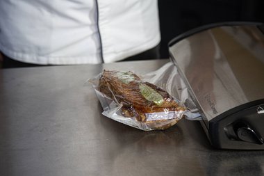 Das Kalbfleisch mit Kräutern und Gewürzen vakuumieren.