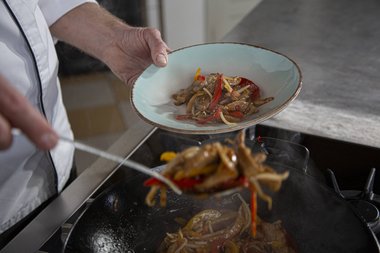 Die Kalbsfleischstreifen aus der Pfanne geben