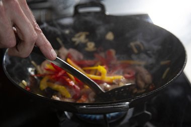 Das Gemüse beifügen und 1 Minute mit dem Fleisch im Wok braten